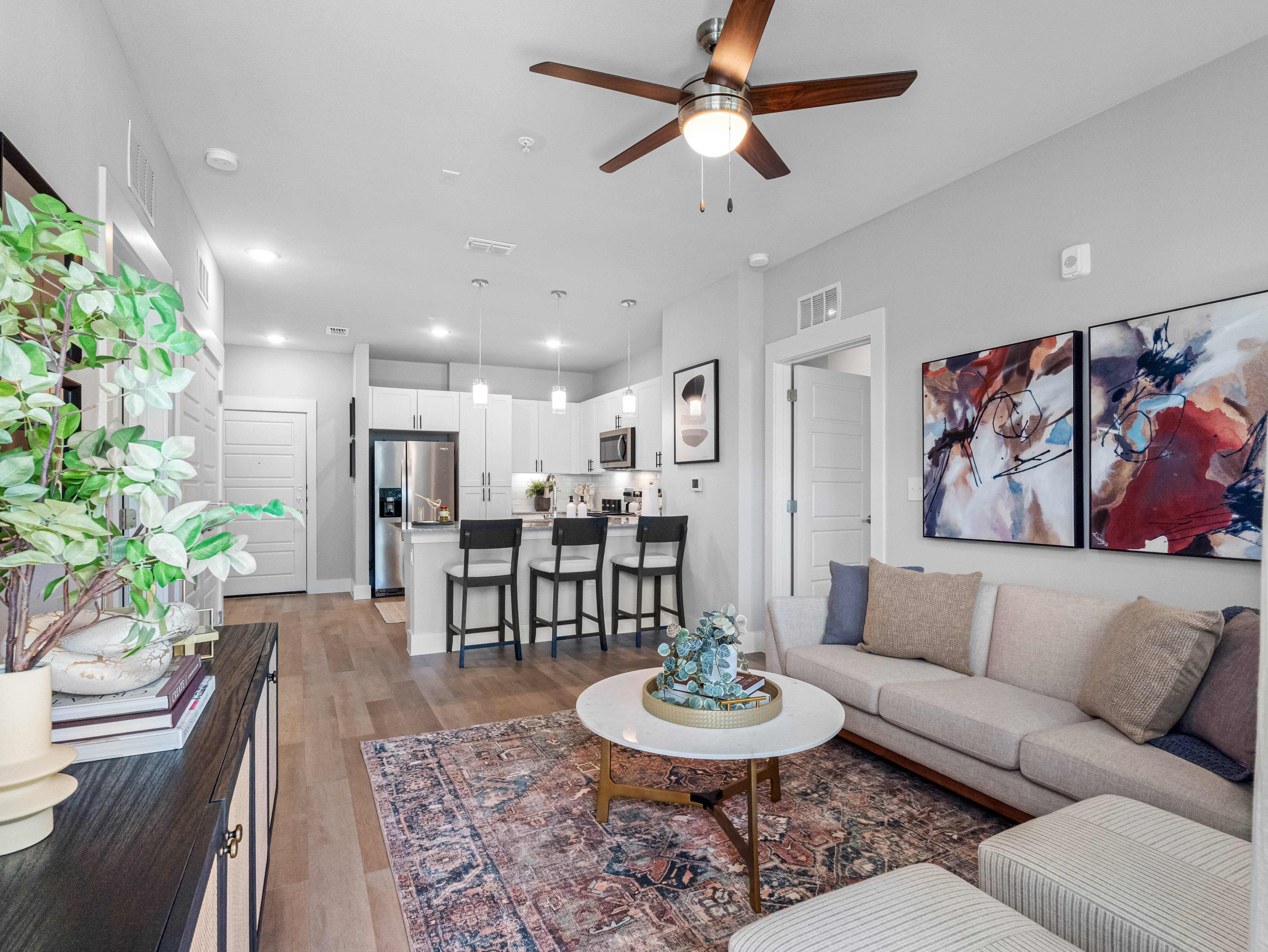 A living room with a couch, coffee table, and a ceiling fan.